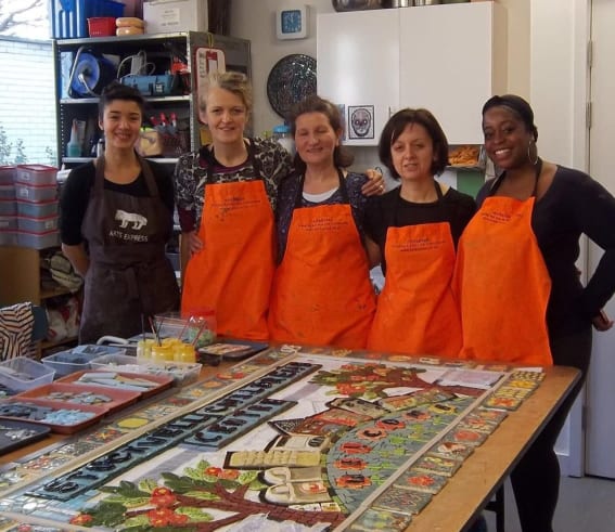group of people wearing orange aprons