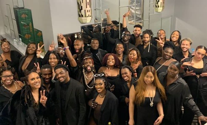 Picture of a group of people dressed in black and smiling