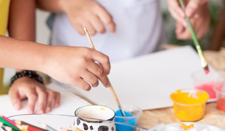 Hands holding paint brushes
